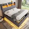 A modern bedroom with a grey upholstered bed featuring integrated storage and lighting.
