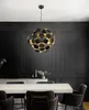 A modern dining room with a black paneled wall, a light-colored dining table, and chairs, illuminated by a spherical chandelier. Podgląd zdjęcia produktu