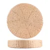 A round, thick seat cushion pouf made of woven natural material, shown from a top and side view. Voir les images du produit