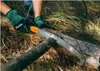 A person wearing green gloves is using a saw to cut a log in a natural outdoor setting. Produktbild-Vorschau