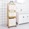 A bamboo laundry basket with three fabric bins and wheels, placed next to a white vanity in a tiled bathroom. Anteprima dell’immagine prodotto