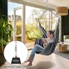 A woman sits in a hanging chair indoors, holding a mug, with a view of a garden through glass doors. Produktbild-Vorschau