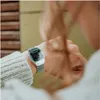 A person wearing a silver digital watch on their wrist. Produktbild-Vorschau