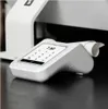 A close-up shot of a white card reader with a receipt dispenser, placed on a dark surface. Produktbild-Vorschau