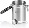 A stainless steel coffee canister with its lid open, next to a measuring scoop. Anteprima dell’immagine prodotto