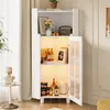 A white cabinet with glass doors, displaying various items on its shelves, including books, bottles, and decorative objects. The cabinet is illuminated from within. Produktbild-Vorschau