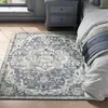 A bedroom scene with a rug, nightstand, and bed.
