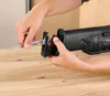 A person is shown inserting a saw blade into a reciprocating saw. Produktbild-Vorschau