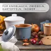 Several ceramic storage containers for vegetables like onions and garlic are displayed on a wooden surface, along with some of the vegetables themselves. The containers are of different sizes and colors, including white, blue-gray, and terracotta. Produktbild-Vorschau