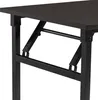 A close-up view of the dark brown tabletop and black metal folding mechanism of a table. Náhľad obrázku produktu