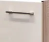 A close-up view of a cabinet handle on a white drawer, with a wood-grain textured side panel visible on the right. Produktbild-Vorschau