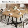 A square wooden dining table set for four people with chairs around it, placed on a patterned rug in a dining room. Produktbild-Vorschau