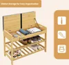 A bamboo shoe rack with a built-in storage bench, showing its open compartment and shelves filled with shoes and accessories. Produktbild-Vorschau