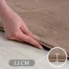 A hand is shown pressing down on the edge of a beige carpet, with a close-up inset showing the carpet's thickness. Podgląd zdjęcia produktu