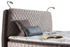 A close-up view of a bed with a tufted headboard, pillows, and a mattress. Produktbild-Vorschau