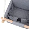 Close-up view of a baby swing seat with a wooden bar and rope. Produktbild-Vorschau