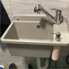 A sink with a faucet and soap dispenser mounted on a tiled wall. Náhled obrázku produktu