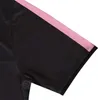 A close-up view of a black t-shirt sleeve with a pink stripe. Produktbild-Vorschau