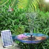 A solar-powered bird bath fountain in a garden setting with a bird flying nearby. Produktbild-Vorschau