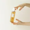 Hands holding a bottle of beauty product against a white background. Anteprima dell’immagine prodotto