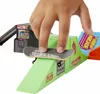 A child's hand is using a fingerboard on a miniature skatepark ramp with arcade-themed elements. Produktbild-Vorschau