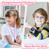 A collage showing a girl wearing a smartwatch on a lanyard around her neck and a boy wearing a smartwatch on his wrist, with art supplies in the foreground. Produktbild-Vorschau