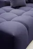 A close-up view of a tufted blue sofa. Náhled obrázku produktu