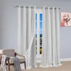A chair with a blanket draped over it sits next to a window with white curtains. Voir les images du produit
