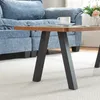 A close-up view of a coffee table with a blue sofa in the background. Podgląd zdjęcia produktu