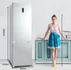 A woman stands next to a refrigerator in a kitchen setting, with dimensions indicated. Produktbild-Vorschau