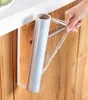 A hand is pulling plastic wrap from a roll holder mounted under a kitchen counter. Podgląd zdjęcia produktu