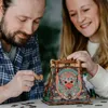 A man and a woman are assembling a wooden puzzle shaped like a pyramid. Náhľad obrázku produktu