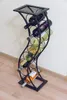 A black metal wine rack holding several bottles of wine against a light-colored wall and wooden floor. Anteprima dell’immagine prodotto