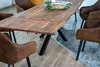 A dining table with chairs in a room. Produktbild-Vorschau