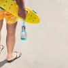 A person holding a yellow skateboard and a blue water bottle. Anteprima dell’immagine prodotto