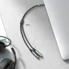A close-up shot of a Ugreen audio splitter cable on a textured surface, with a portion of a laptop visible on the right. Podgląd zdjęcia produktu
