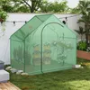 A green greenhouse filled with potted plants sits on a grassy lawn. Podgląd zdjęcia produktu