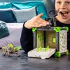 A child is playing with a Schleich Eldrador Creatures Battle Cave toy set, featuring a creature and a cave-like structure. Produktbild-Vorschau