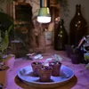 A grow light illuminates small plants in pots on a wooden surface, with bottles in the background. Anteprima dell’immagine prodotto