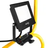 A black LED floodlight is mounted on a yellow stand. Náhled obrázku produktu