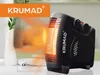 A black KRUMAD heater is shown on a table, emitting orange heat waves towards a white vase with a plant. Voir les images du produit