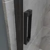 Close-up of a black shower door handle against a tiled wall. Produktbild-Vorschau