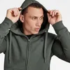 A man wearing a green hooded jacket. Produktbild-Vorschau