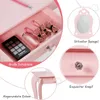 A close-up view of a pink wooden children's vanity table drawer, showcasing makeup and hair accessories, with callouts highlighting features like the mirror, drawer knob, and rounded corners. Náhľad obrázku produktu