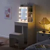 A vanity table with a lighted mirror and stool in a bedroom setting. Voir les images du produit
