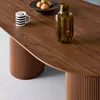 A close-up view of a wooden dining table with a vase and a mug on it. Produktbild-Vorschau