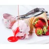 A close-up of strawberry ice cream being served with a scoop and cone, with strawberries and syrup. Náhľad obrázku produktu