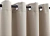 Close-up view of beige grommet curtains hanging on a black curtain rod. Produktbild-Vorschau