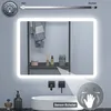 A bathroom scene featuring an illuminated LED mirror above a sink, with decorative items on a shelf behind it. Produktbild-Vorschau