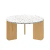 A round coffee table with a terrazzo-like top and wooden legs, presented against a white background. Voir les images du produit